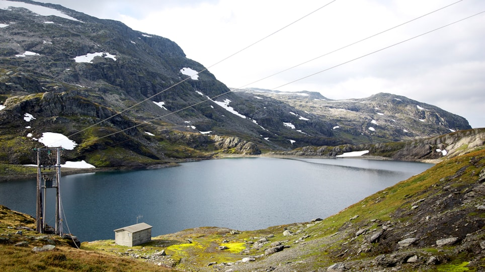 Bilde av vann fjell og kraftmast