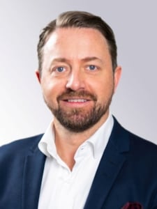 Portrettfoto av Tobias Bang-Hansen i studio med hvit bakgrunn.